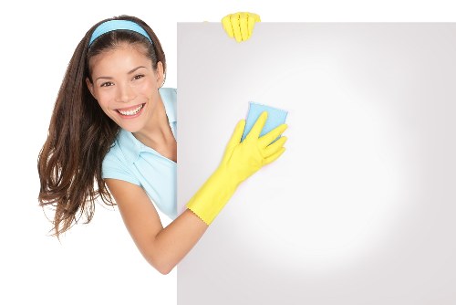 Staff member inspecting cleaning equipment and following safety procedures